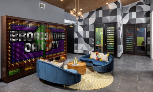 a clubroom with a large screen, couches and a table
