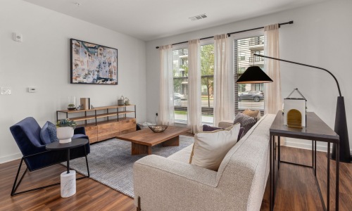 a living room with a couch, tables and a chair